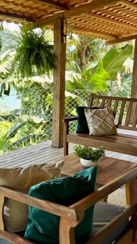 ein Holztisch mit Kissen auf einer Veranda in der Unterkunft Casa da Praia in Paraty
