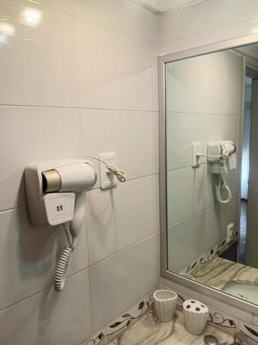 een badkamer met een haardroger en een spiegel bij peninsula fontemar in Punta del Este