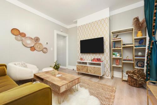 a living room with a couch and a tv at HostWise Stays - The Geneva - Easy Walk to Childrens in Pittsburgh
