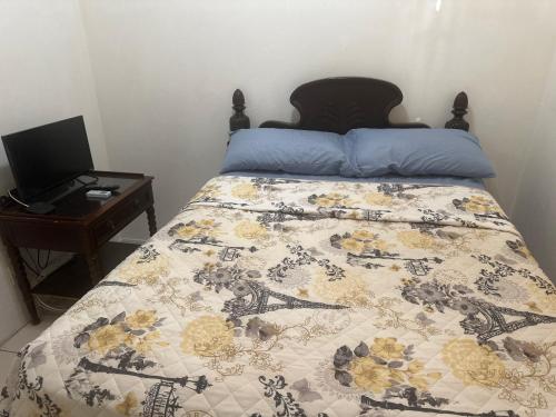 una camera da letto con un letto e una scrivania con un computer portatile di O E Liburd Residence a Charlestown