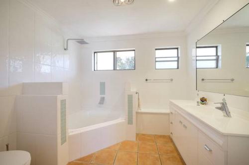 a bathroom with a tub and a toilet and a sink at Vista at Straddie View in Dunwich