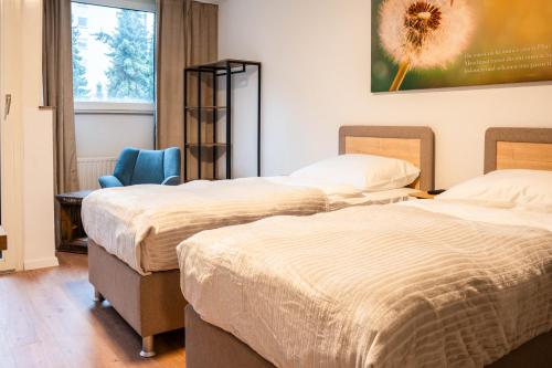 Cette chambre comprend deux lits, un bureau et une chaise. dans l'établissement Luxury Homburg, à Hombourg