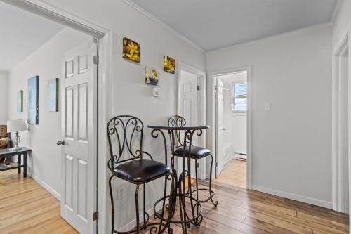 a hallway with a table and two black stools at Modern 2BR Suite Parking Laundry in Torbay