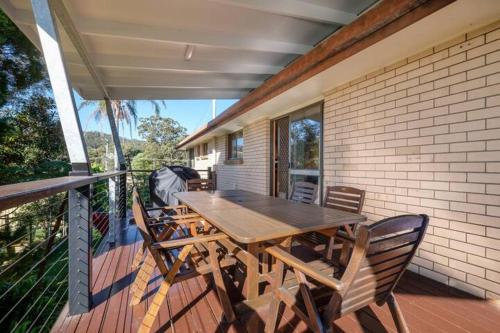 a wooden table and chairs sitting on a porch at Vista at Straddie View in Dunwich