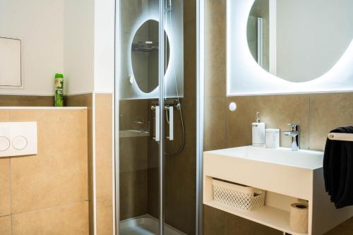 une salle de bain avec douche et lavabo dans l'établissement Luxury Homburg, à Hombourg