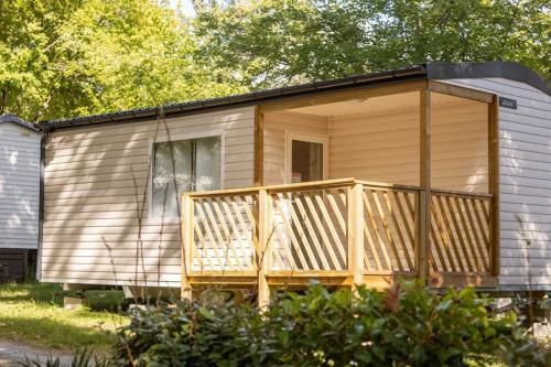 a tiny house with a porch and a deck at ZEcamping 4 étoiles 4km plage parc aquatique fitness dog friendly club enfant in Saint-Sulpice-de-Royan