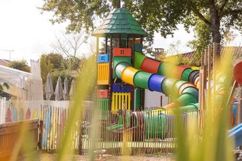 a playground with a colorful slide in a park at ZEcamping 4 étoiles 4km plage parc aquatique fitness dog friendly club enfant in Saint-Sulpice-de-Royan
