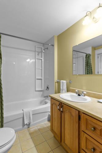 a bathroom with a sink and a tub and a toilet at Cozy Manor Studio Parking WiFi in St. John's