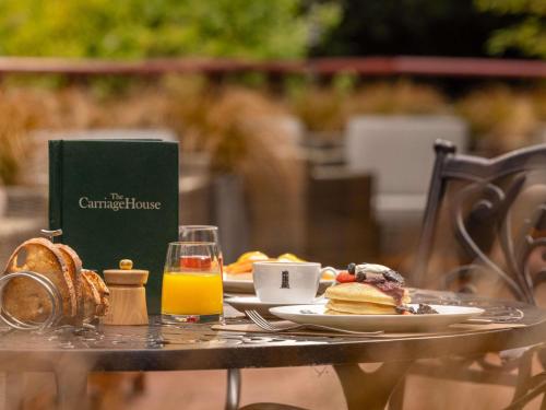 a table with a plate of breakfast food and orange juice at Carton House A Fairmont Managed hotel in Maynooth