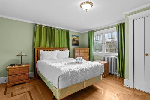 een slaapkamer met groene gordijnen, een bed en een raam bij Midstream Manor 1BR Parking WiFi in St. John's