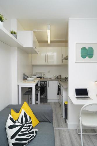 a living room with a couch and a kitchen at New Refurbish Studio to rent in Euston - Central London in London