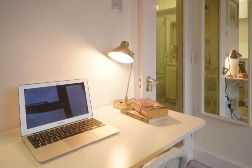 a laptop computer sitting on a desk with a lamp at New Refurbish Studio to rent in Euston - Central London in London