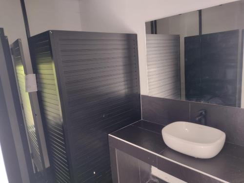 een badkamer met een wit toilet en een spiegel bij Finca Hotel Rancho Cattleya in Estación El Salto