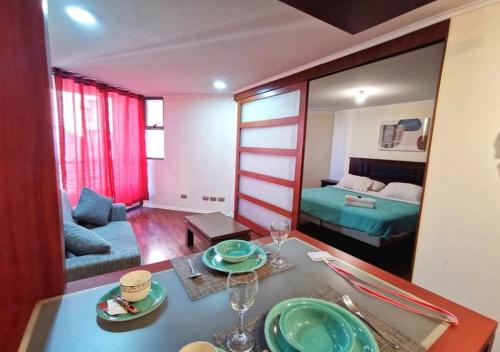 een woonkamer met een eettafel en een slaapkamer bij Apart Merced Home in Santiago