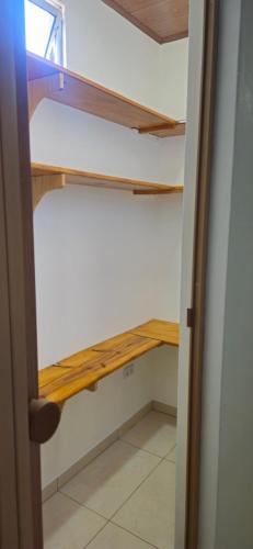 armadio con ripiani in legno in camera di Apê da Lili a Ilha de Boipeba