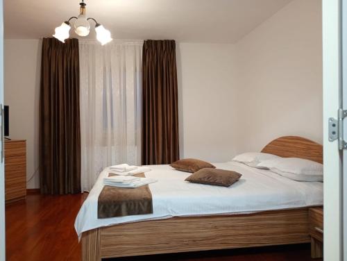a bedroom with a bed with white sheets and a window at Apartament Adelina Borsa in Borşa