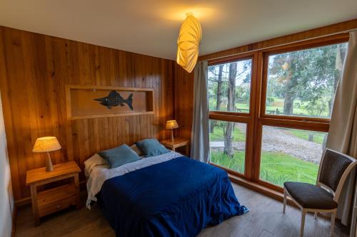 a bedroom with a bed and a large window at Complejo Pelicano Chapadmalal in Chapadmalal