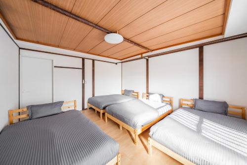 2 Betten in einem Zimmer mit Fenstern in der Unterkunft King Deer in Higashikawa