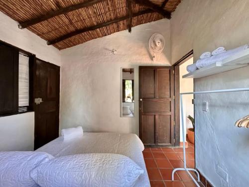 a bedroom with a bed and a wooden door at Runa Barichara in Barichara