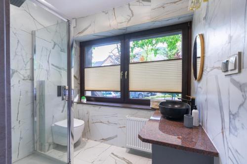 ein Badezimmer mit Dusche und Toilette und einem Fenster in der Unterkunft Apartamenty Sarnia 6A in Karpacz