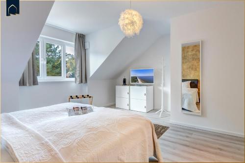a white bedroom with a bed and two windows at Ostseenest Bernstein in Kölpinsee