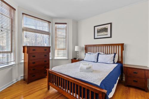 een slaapkamer met een bed, een dressoir en 2 ramen bij Charming 2BR Wi-Fi Off-Street Parking in St. John's