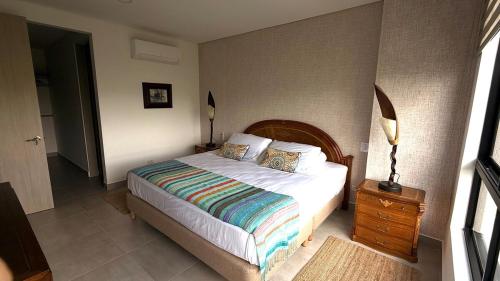 a bedroom with a bed and a night stand with a lamp at Apartamento Campestre 6 Pax in Armenia