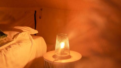 een lamp op een tafel naast een bed bij ASILI DELUXE - Zebra in Lichtaart