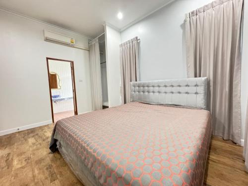 una camera da letto con un letto grande e uno specchio di Villa88 สันกำแพงสายใหม่ 