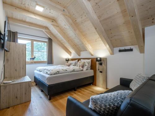 a bedroom with a bed and a couch at Chalet Karibu in Donnersbachwald