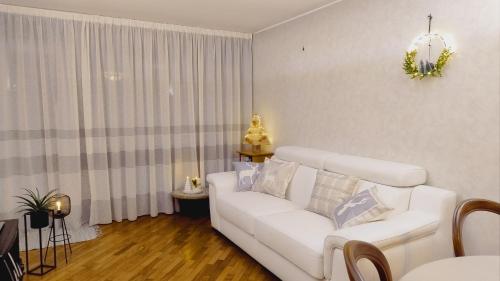 un soggiorno con divano bianco e finestra di Da NOEMI E MARCO a Cavalese