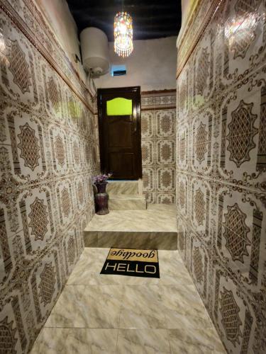 Un pasillo con una pared con una puerta y un piso de baldosas. en Cozy Nest, en Sale