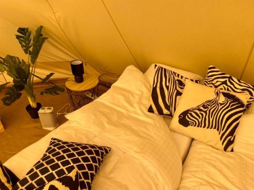 a bed with pillows with a zebra head on it at ASILI DELUXE - Zebra in Lichtaart
