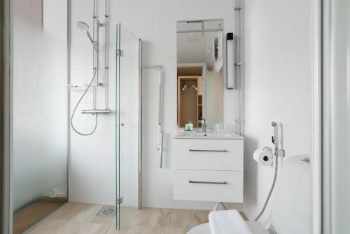 un bagno bianco con doccia e lavandino di Polar Nook Hotel a Rovaniemi