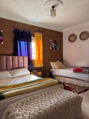 a bedroom with two beds and a window at HOTEL 7DAYS DAkHLA in Dakhla