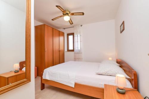 a bedroom with a bed and a mirror at Apartments with a parking space Mali Losinj (Losinj) - 376 in Mali Lošinj