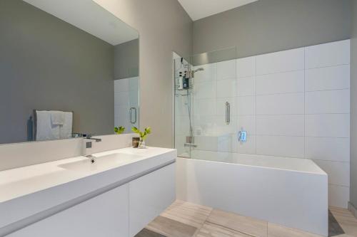 een witte badkamer met een bad en een wastafel bij Bishop's Lane in Sandspit