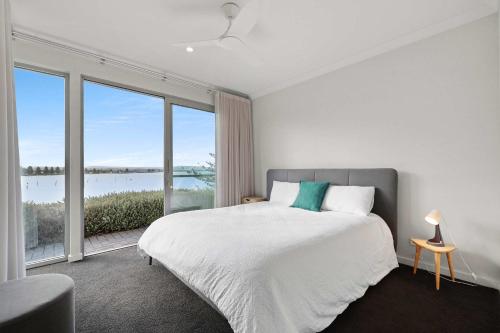 een witte slaapkamer met een bed en een groot raam bij The Bluff Villa 4-121 Franklin Pde Encounter Bay - Linen Included in Encounter Bay