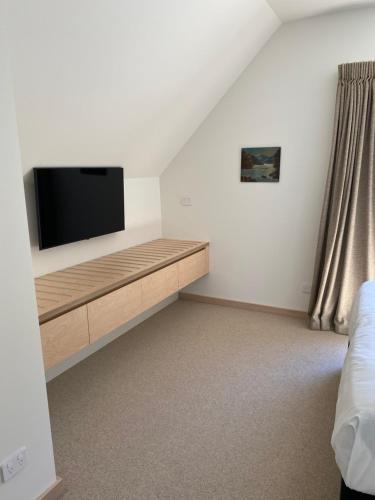 a room with a flat screen tv on a wall at Wilden Apartments in Queenstown