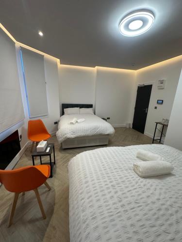 een hotelkamer met twee bedden en een stoel bij AMD Hotel Wallington SM6 in Wallington