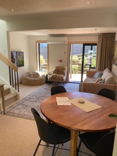 a living room with a wooden table and chairs at Wilden Apartments in Queenstown