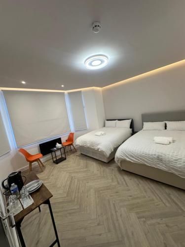 een slaapkamer met twee bedden en een tafel en stoelen bij AMD Hotel Wallington SM6 in Wallington