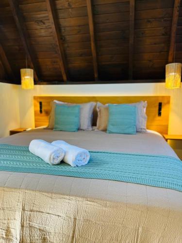 a large bed with two towels on top of it at Studio Na Natureza Com Hidro - Baoba Suites in Bombinhas