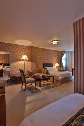 ein Hotelzimmer mit zwei Betten und einem Tisch in der Unterkunft The Residence Hotel in Addis Abeba