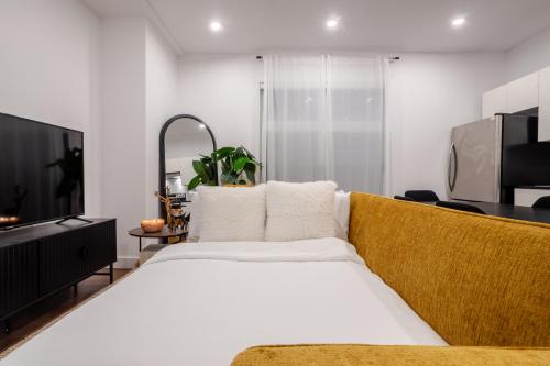 a bedroom with a large bed and a television at Stylish Retreat Near Crescent & Sainte-Catherine in Montréal