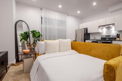 a bedroom with a bed and a kitchen at Stylish Retreat Near Crescent & Sainte-Catherine in Montréal