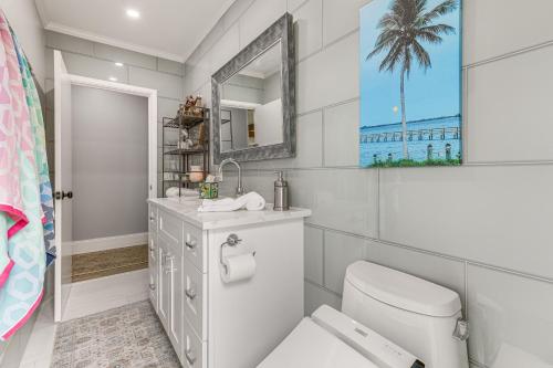 ein Badezimmer mit Toilette, Waschbecken und Spiegel in der Unterkunft Jensen Beach Indian River Waterfront Retreat in Eden