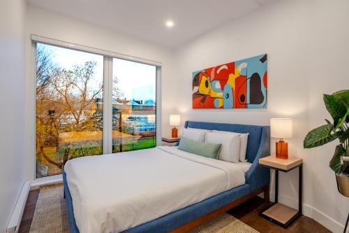 a bedroom with a bed and a large window at Stylish Retreat Near Crescent & Sainte-Catherine in Montréal