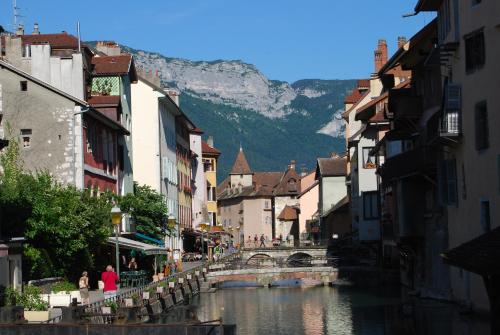 une rue d'une ville avec un pont sur une rivière dans l'établissement Hôtel des Alpes, à Annecy
