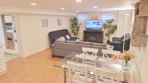 a living room with a couch and a table and chairs at Richview Gardens Apartment in Toronto